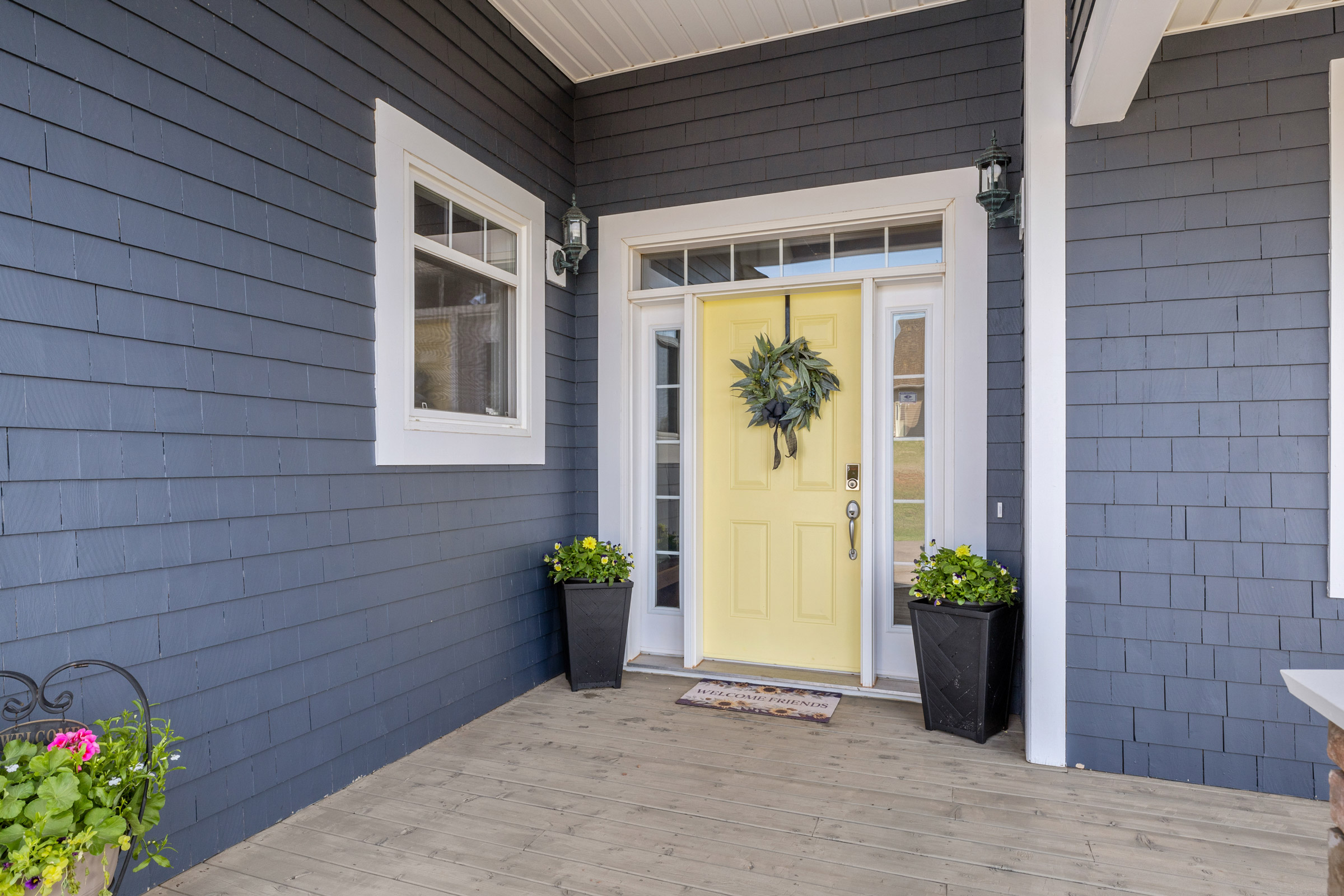 If you're selling a home in PEI touches like this wreath on a yellow door with planters on either side can emphasize a homey feel to potential buyers